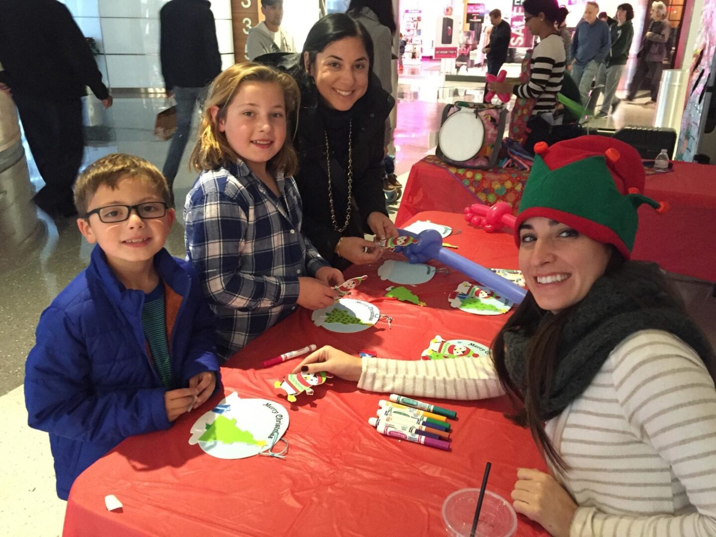 two adults and two kids at a craft table