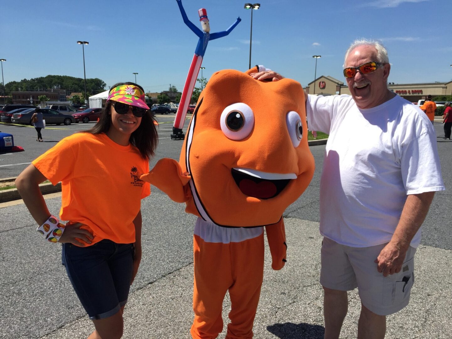 a nemo mascot posing with two adults